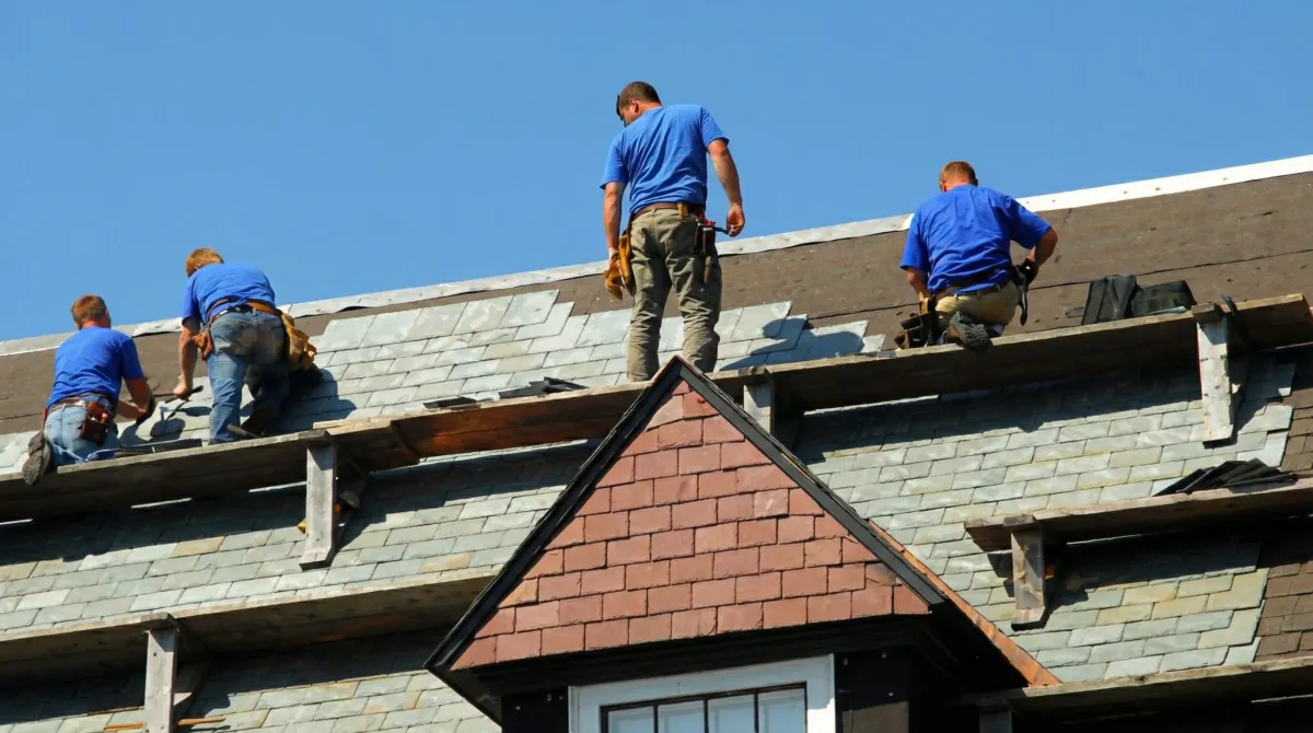 Roof replacement in progress with a team of professional contractors installing new shingles on a residential home in Indianapolis, IN